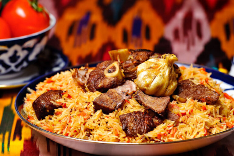 plov uzbeko servito con carne e aglio in piatto blu